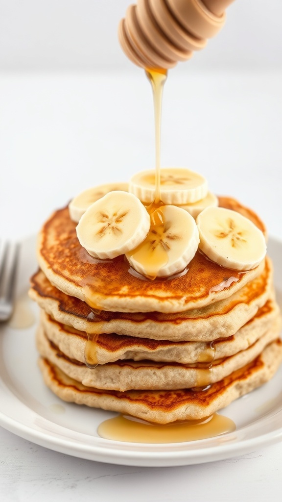 Whole Wheat Banana Pancakes Recipe Fluffy whole wheat banana pancakes topped with bananas and honey on a white plate.